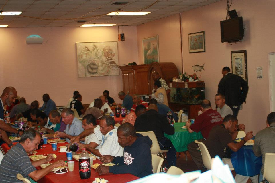 Large group of people sharing a meal together at Miami Street Outreach community feeding event